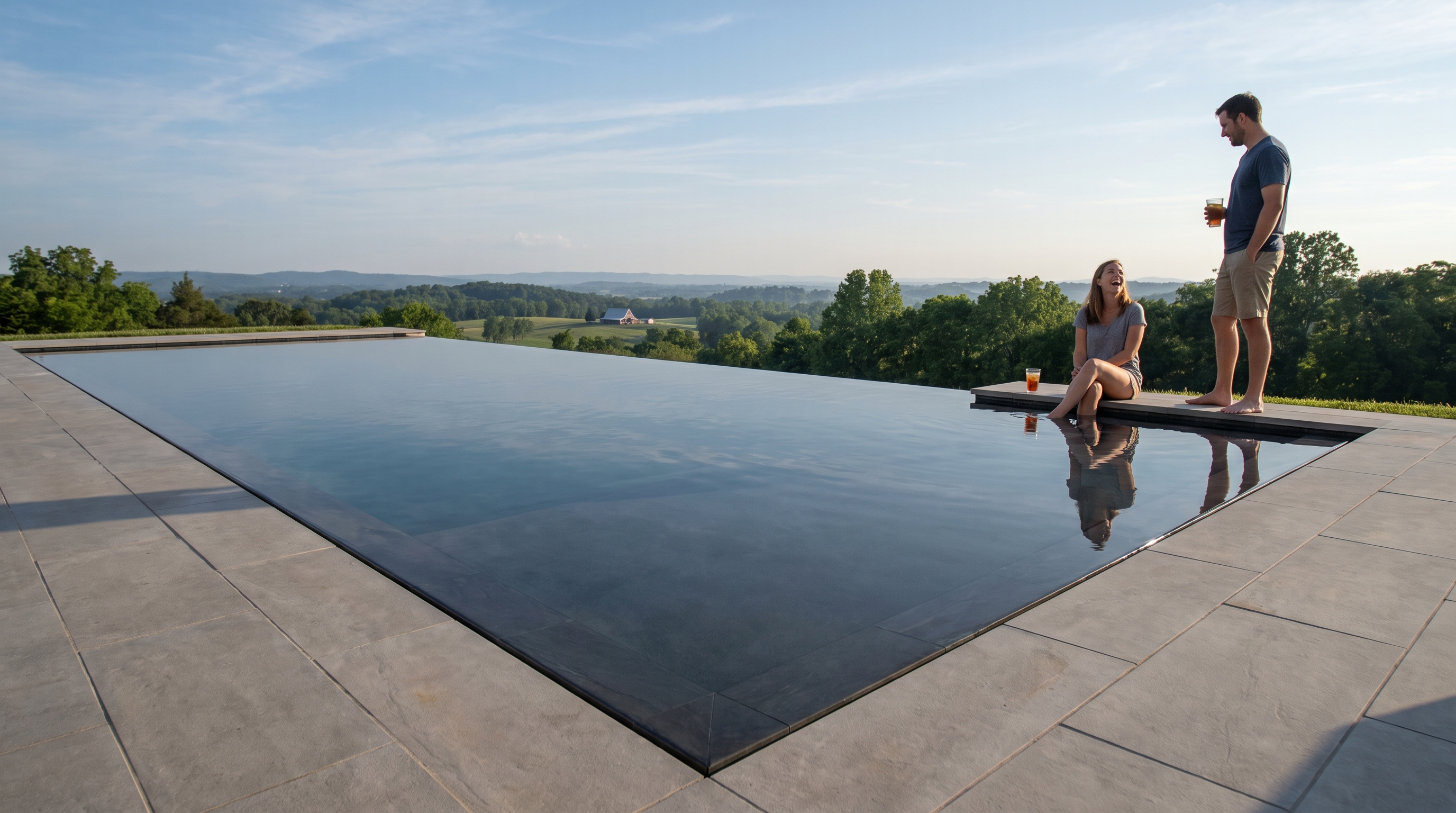 Rectangular infinity-edge pool with water spilling toward rolling Tennessee hills at golden hour